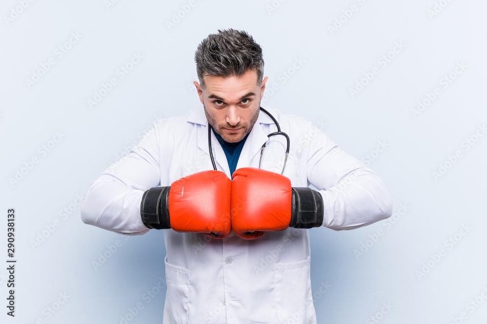 Caucasian doctor man wearing boxing gloves