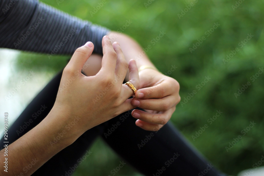 Pretty young girl dressed in gray putting a ring on her finger. Pretty young girl dressed in gray putting a ring on her finger.