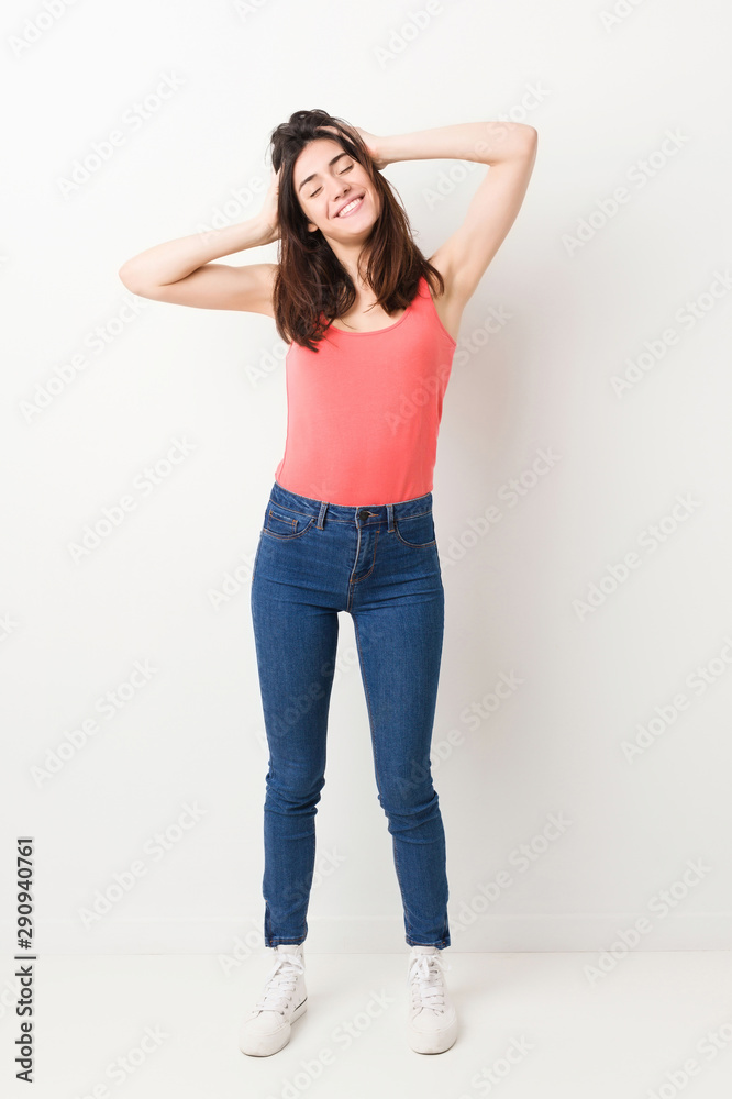 Full body young woman on white background laughs joyfully keeping hands on head. Happiness concept. Full body young woman on white background laughs joyfully keeping hands on head. Happiness concept.