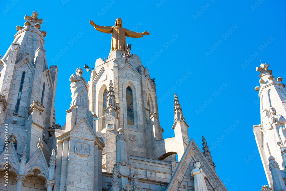 Fototapeta premium Golden Statue of Jesus Christ on the facade of the Temple of the Sacred Heart of Jesus, Barcelona, Catalonia, Spain.