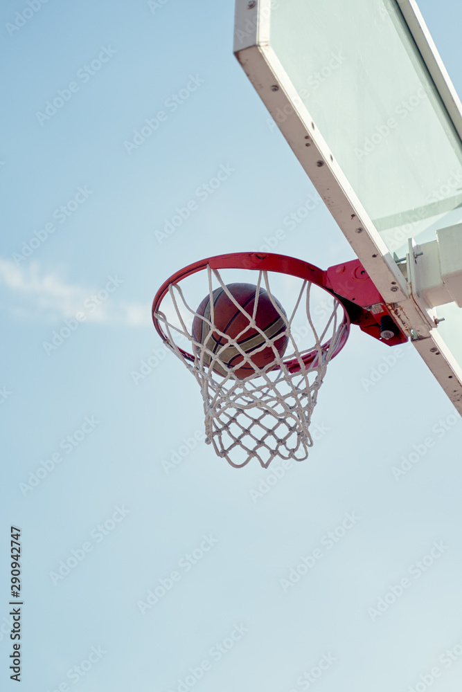 Photo of basketball hoop against blue sky .