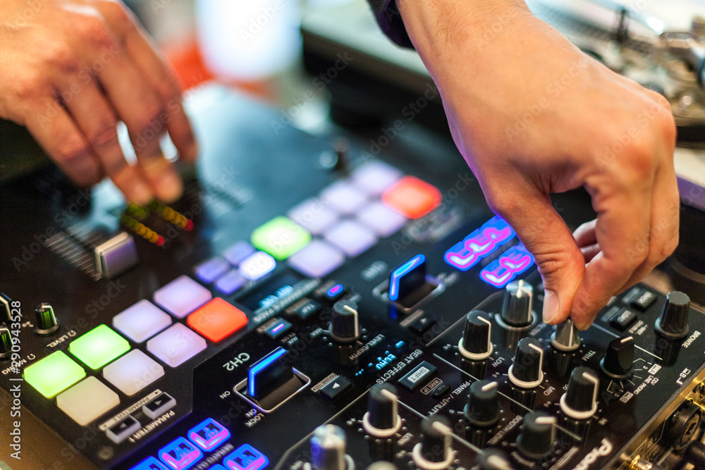 close-up photography of dj hands mixing music in a club, selective focus.