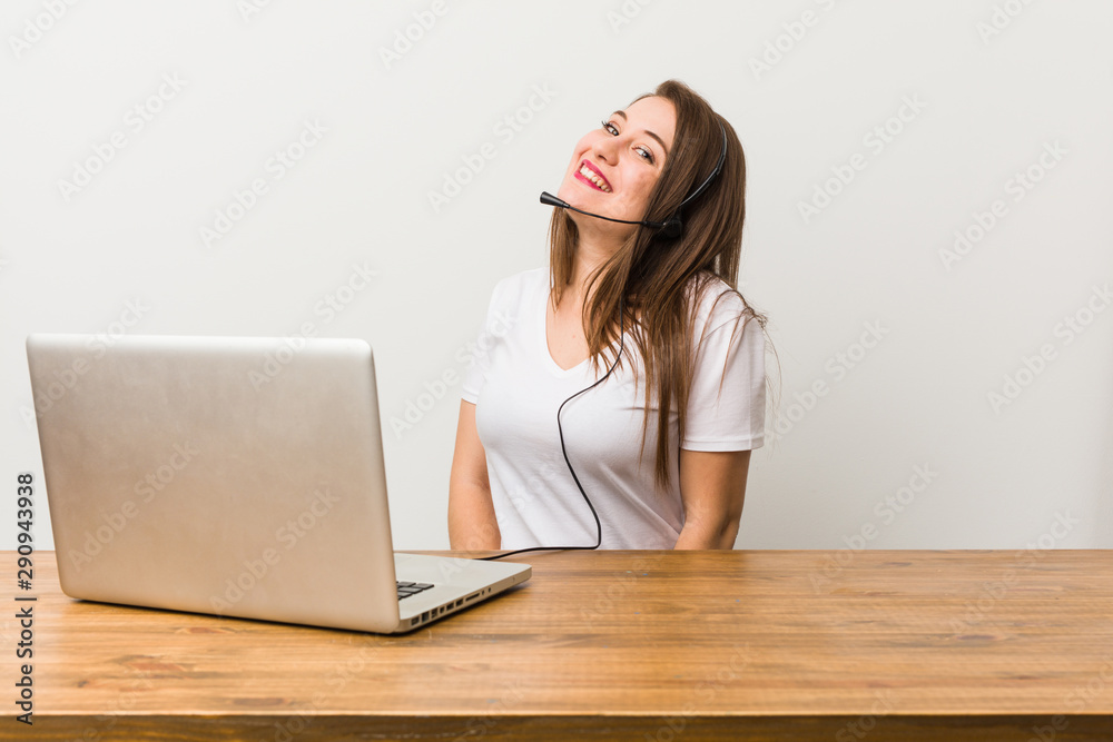 Young telemarketer woman looks aside smiling, cheerful and pleasant.