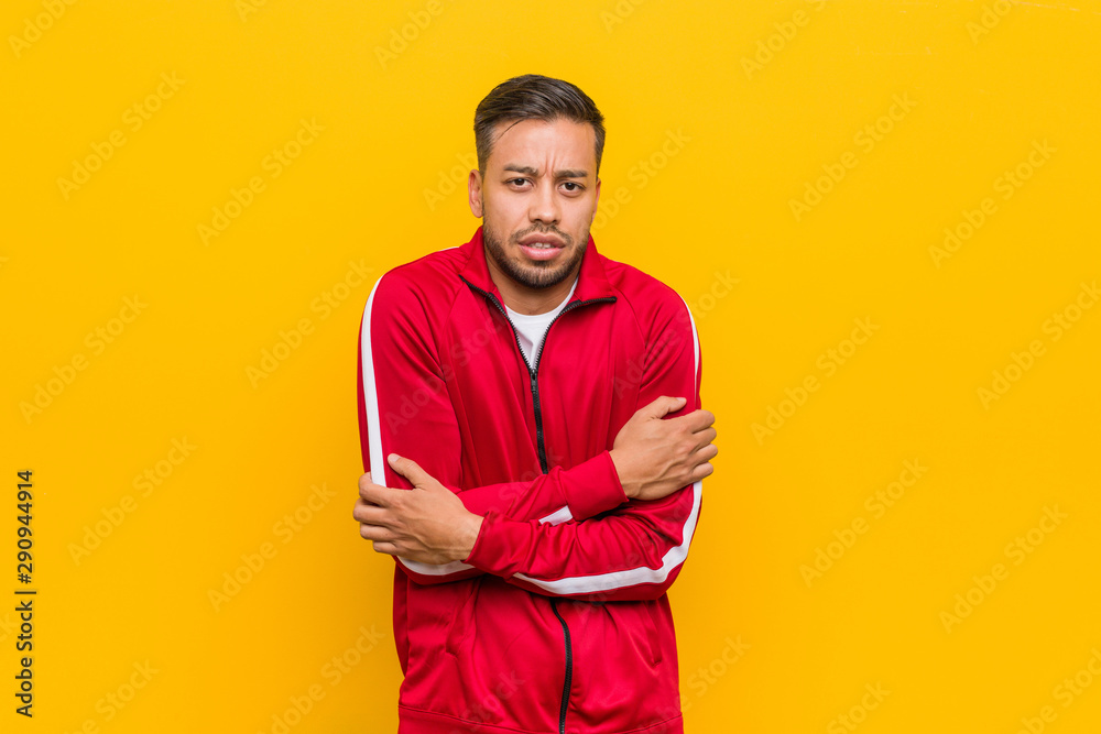Young filipino fitness man going cold due to low temperature or a sickness.