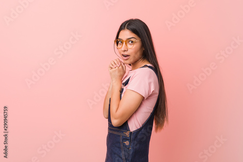 Young pretty arab woman wearing a jeans dungaree scared and afraid.