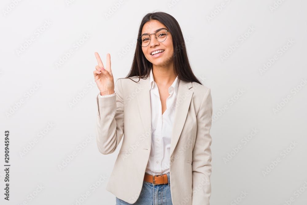 Young business arab woman isolated against a white background joyful and carefree showing a peace symbol with fingers. Young business arab woman isolated against a white background joyful and carefree showing a peace symbol with fingers.
