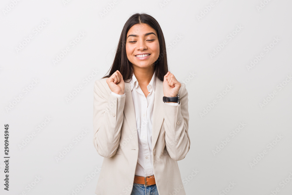 Young business arab woman isolated against a white background raising fist, feeling happy and successful. Victory concept. Young business arab woman isolated against a white background raising fist, feeling happy and successful. Victory concept.