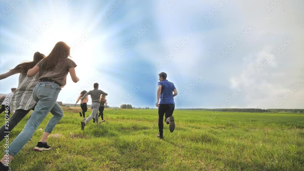 Happy friends run against the backdrop of a beautiful sky and sun. Happy friends run against the backdrop of a beautiful sky and sun.