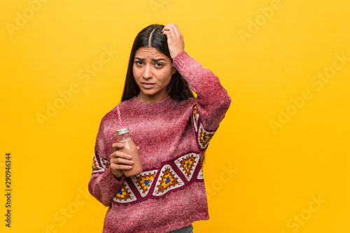 Young arab woman holding a smoothie being shocked, she has remembered important meeting. © Asier