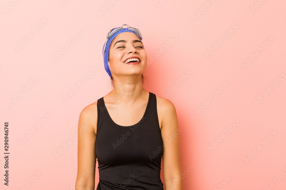 Young arab swimmer woman isolated relaxed and happy laughing, neck stretched showing teeth. Young arab swimmer woman isolated relaxed and happy laughing, neck stretched showing teeth.