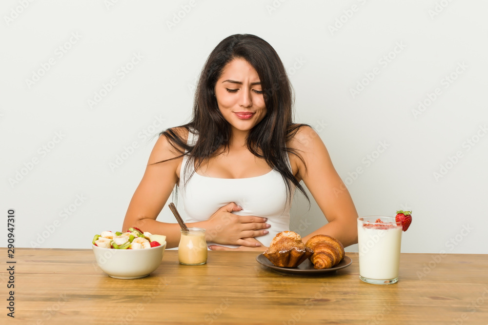 Young curvy woman taking a breakfast sick, suffering from stomachache, painful disease concept. Young curvy woman taking a breakfast sick, suffering from stomachache, painful disease concept.