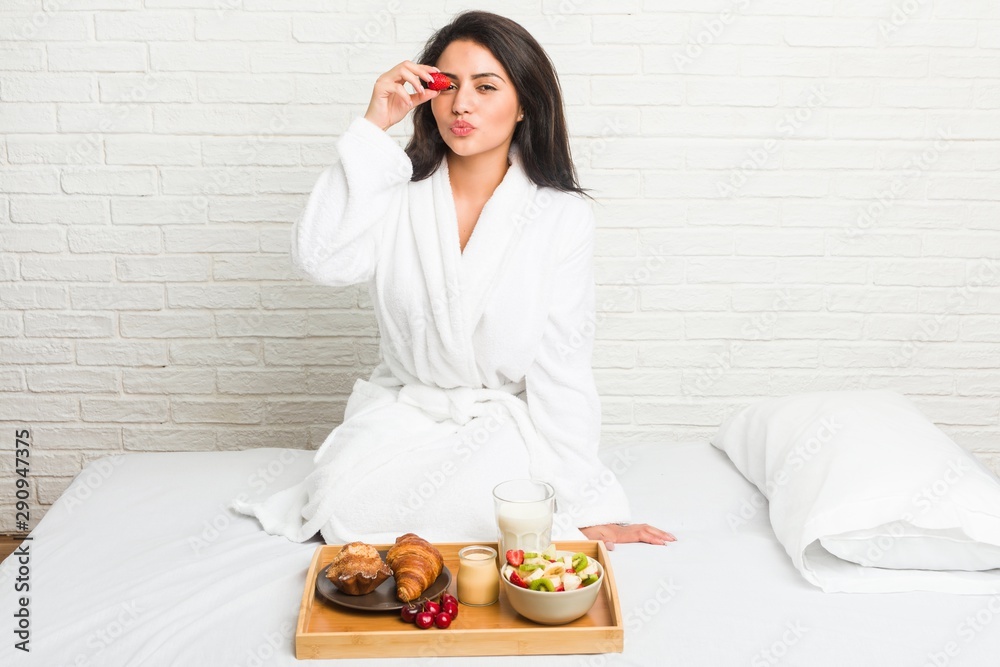 Young hispanic woman having breakfast on the bed Young hispanic woman having breakfast on the bed
