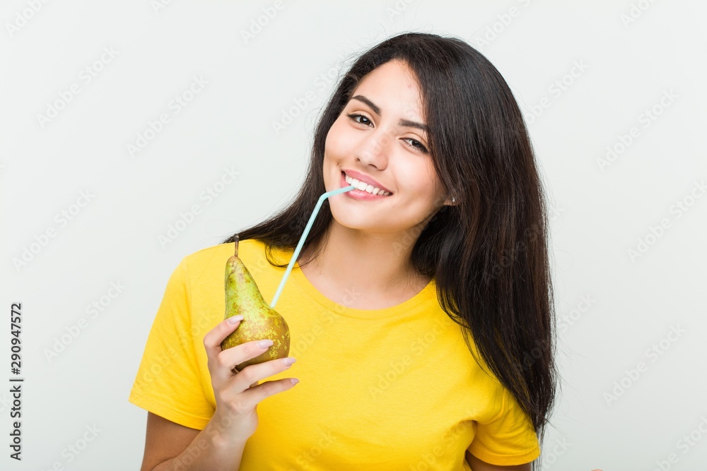 Young hispanic woman drinking a pear juice with a straw Young hispanic woman drinking a pear juice with a straw