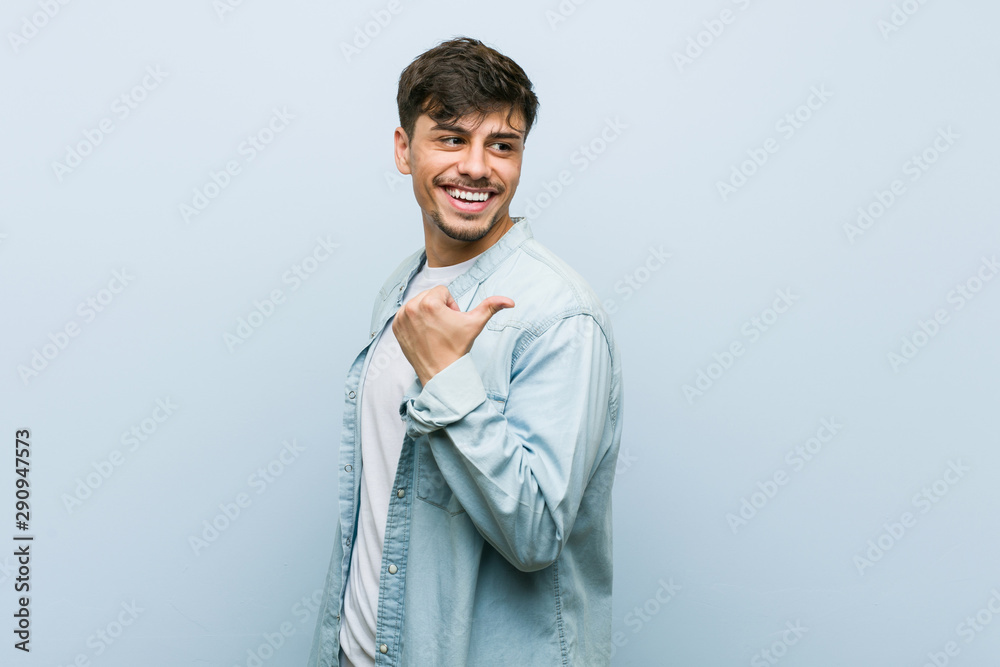 Young hispanic cool man points with thumb finger away, laughing and carefree. Young hispanic cool man points with thumb finger away, laughing and carefree.