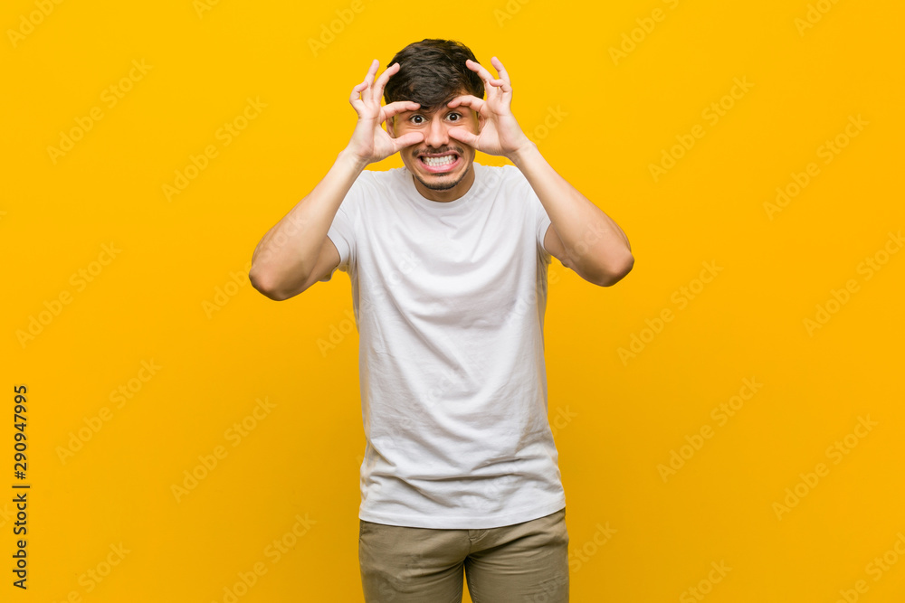 Young hispanic casual man keeping eyes opened to find a success opportunity. Young hispanic casual man keeping eyes opened to find a success opportunity.