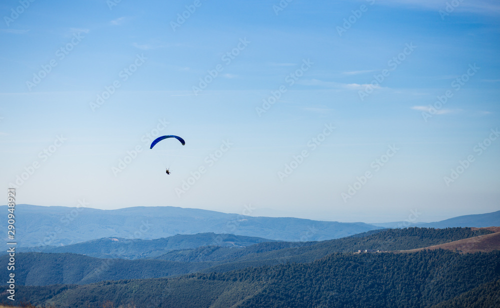 Paraglider flying over mountains peak in autumn day with beautiful aerial world view. Freedom lifestyle concept Paraglider flying over mountains peak in autumn day with beautiful aerial world view. Freedom lifestyle concept