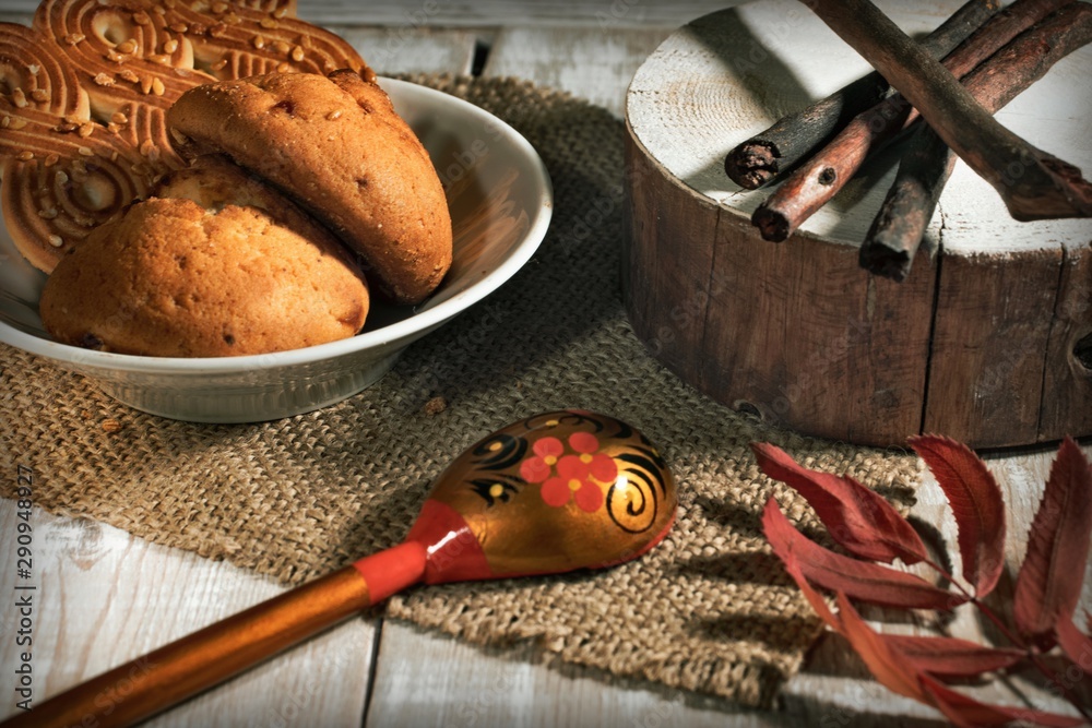 cookies, spoon with a pattern and cloth on a wooden table