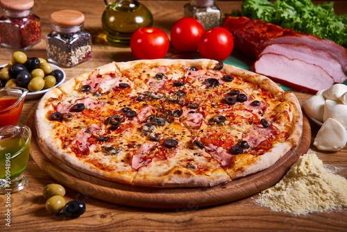 Delicious italian pizza served on wooden table. sliced pizza. tasty pizza composition