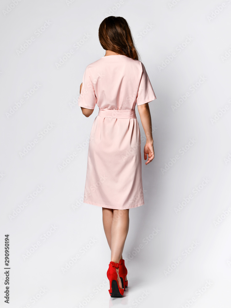 Full length portrait of happy beautiful woman in pink dress posing in studio isolated on white background Full length portrait of happy beautiful woman in pink dress posing in studio isolated on white background