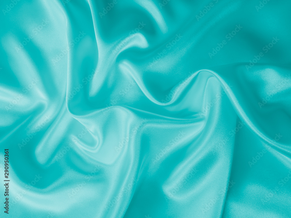 Smooth elegant wavy turquoise blue silk or satin luxury cloth fabric texture, abstract background design. Smooth elegant wavy turquoise blue silk or satin luxury cloth fabric texture, abstract background design.
