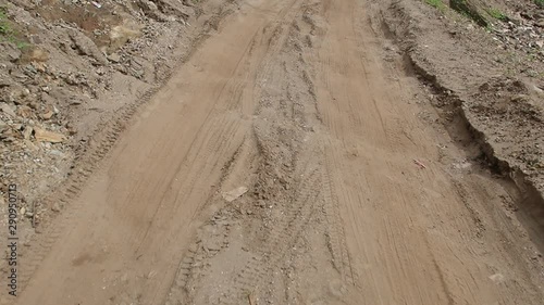 view of the rural dirt road,  Riding on a rough roadway,  Traces of tires on the sand.
