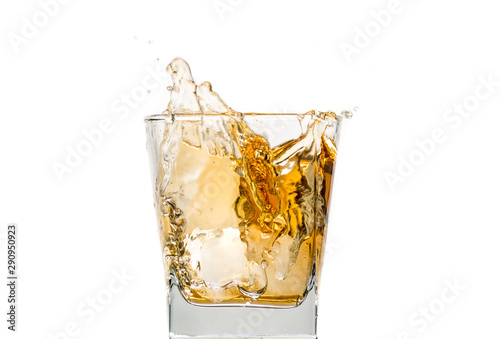 glass of whiskey with ice and a splash and spray from falling on a white background