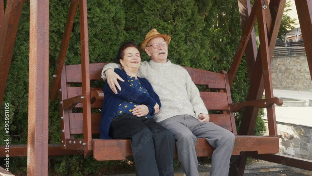 Happy elderly couple on porch swing remember the best years of their life Happy elderly couple on porch swing remember the best years of their life