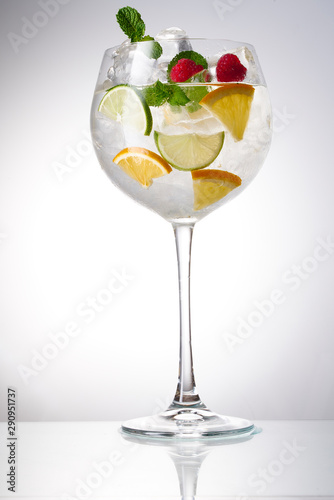 Glass of lemonade with lemon, lime and mint on white background.  Soda water with citrus and ice. Lime and orange in sparkling water