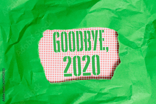 Text sign showing Goodbye 2020. Business photo showcasing New Year Eve Milestone Last Month Celebration Transition Green crumpled ripped colored paper sheet centre torn colorful background photo