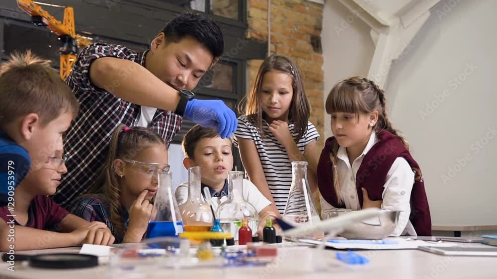 Korean scientist shows young schoolchildren chemical reaction experiments the do a lab class.