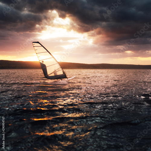 Windsurfing on a lake at sunset.