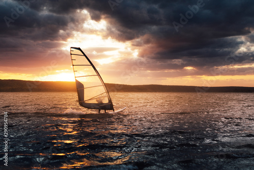 Windsurfing on a lake at sunset. © Аrtranq