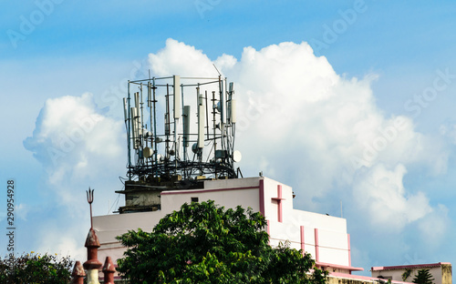 Heavy High Voltage Electric Power Transmission Cell Tower radio Antenna. Broadcast Steel beam tower cellular antenna. Industrial energy power design. Installation on top of roof building. Miniml photo