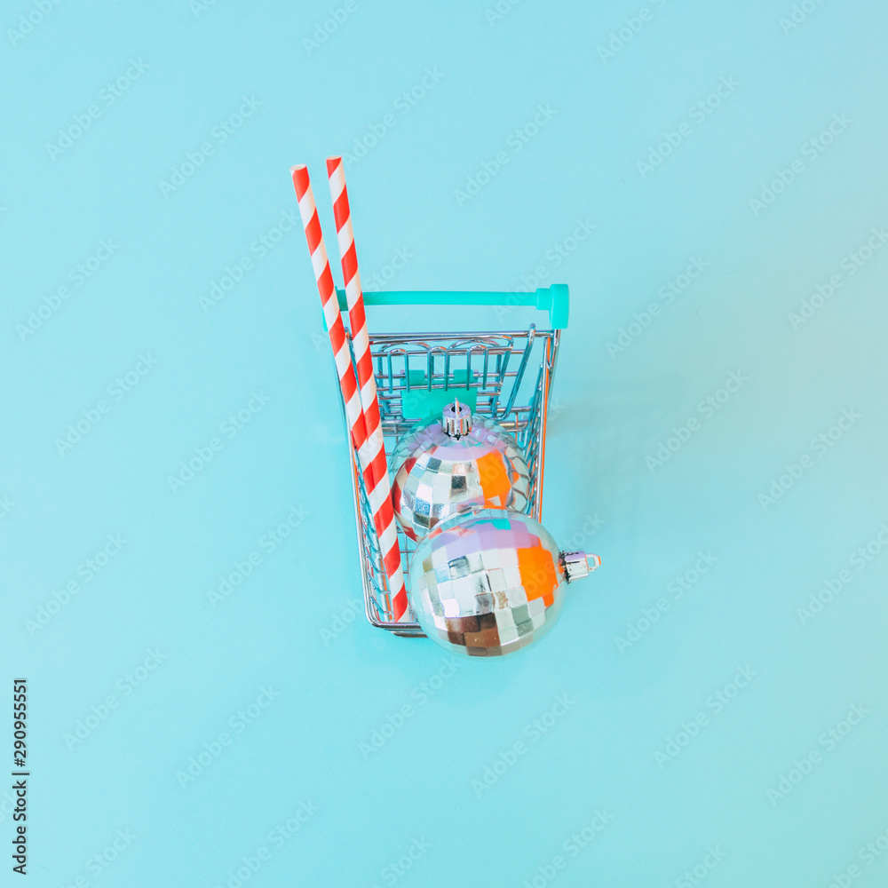 Fototapeta premium Shopping cart full of gifts and Christmas decorations. Minimal, flat lay. Top view