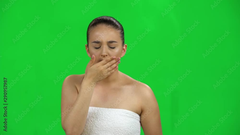 Young woman in the towel gets sick, she has a sore throat, cough, fever