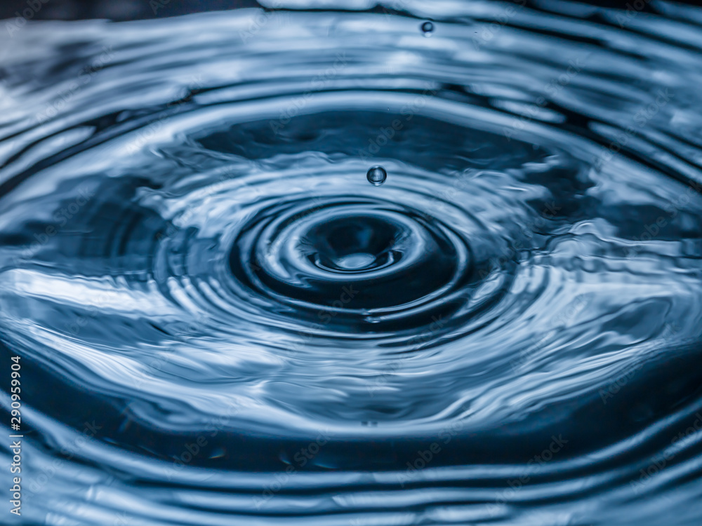 water drop splash in a glass blue colored water drop splash in a glass blue colored