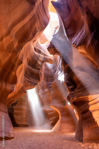 Wide angle view of the vault of the Upper Antelope Canyon with three light beams shining from an opening
