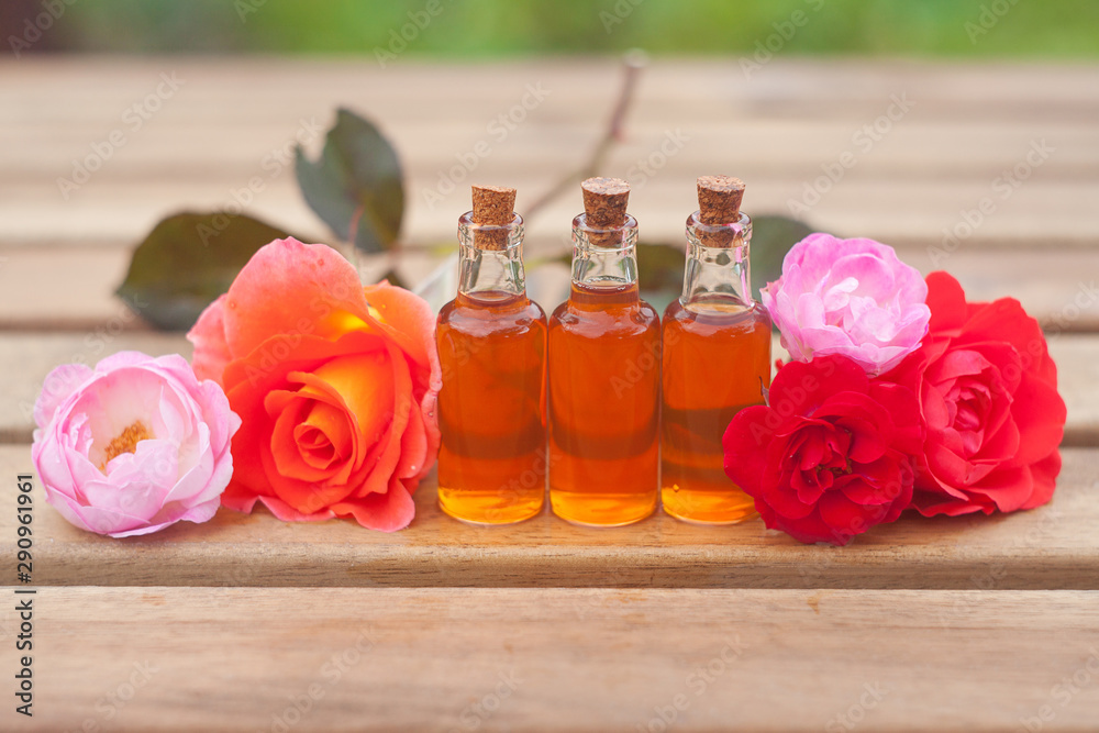 Essence of rose on table in beautiful glass bottle