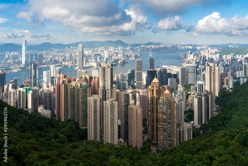 Aerial view of Hong Kong skyline and Victoria Harbor with blue sky in Hong Kong. Asia. Asian tourism, modern city life, or business finance and economy concept.