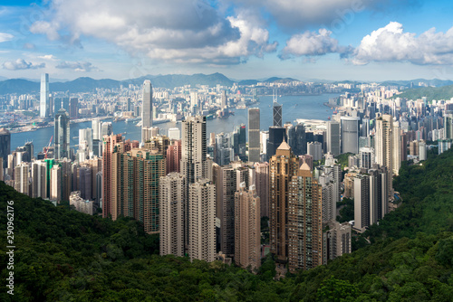 Aerial view of Hong Kong skyline and Victoria Harbor with blue sky in Hong Kong. Asia. Asian tourism, modern city life, or business finance and economy concept.