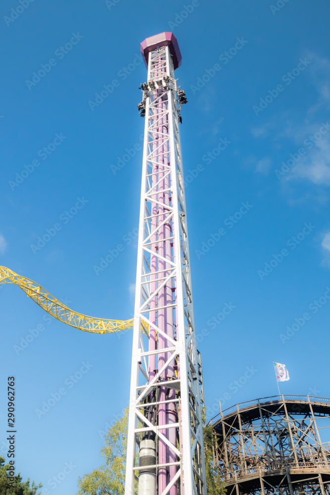 Helsinki, Finland - 14 September 2019: Linnanmaki amusement park, rides tower Raketti in motion and roller coasters Ukko, Vuoristorata Helsinki, Finland - 14 September 2019: Linnanmaki amusement park, rides tower Raketti in motion and roller coasters Ukko, Vuoristorata