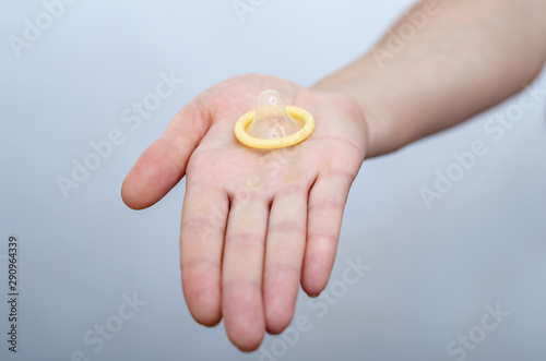 Woman hand holds a condom. Contraceptives, sexually transmitted diseases