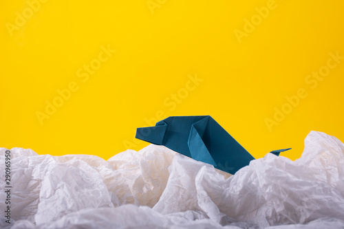 whale on a wave handmade origami craft paper art on a yellow paper background © Xristoforov