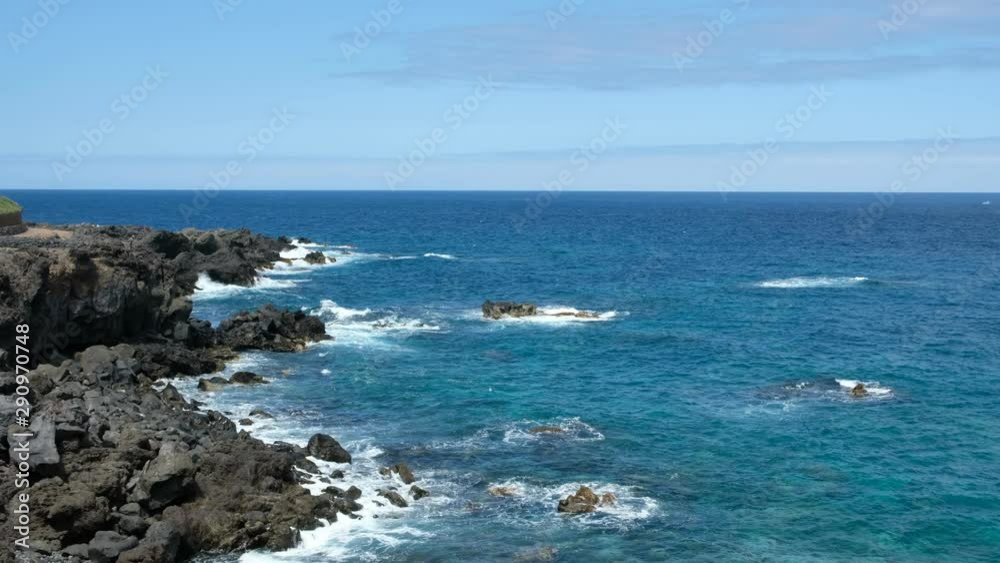 rocky ocean coastline on a sunny day - coast with black rock cliff and ocean horizon rocky ocean coastline on a sunny day - coast with black rock cliff and ocean horizon