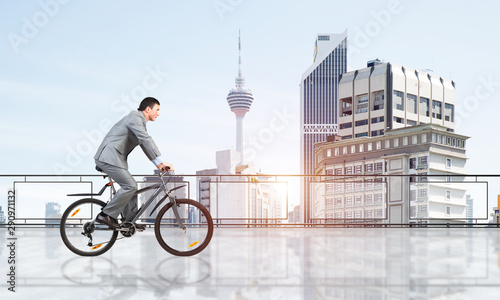 Fototapeta Naklejka Na Ścianę i Meble -  Man riding bicycle on penthouse balcony