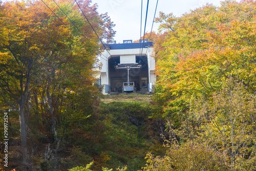 Nikko red cable car with tourists is traveling up to the top of the autumn mountain photo