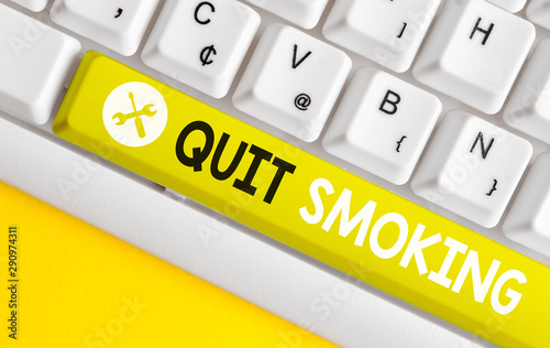 Conceptual hand writing showing Quit Smoking. Concept meaning Discontinuing or stopping the use of tobacco addiction White pc keyboard with note paper above the white background