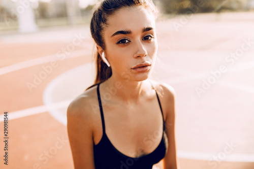 Image of attractive young athletic woman posing sitting outdoors, Relaxing after a workout