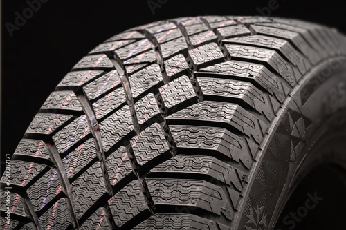 modern winter friction tyres Velcro. safe driving. image wheel on a black background, rubber products, auto parts.