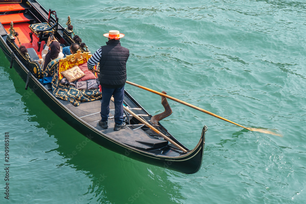Tourists in gondolas on canal of Venice.